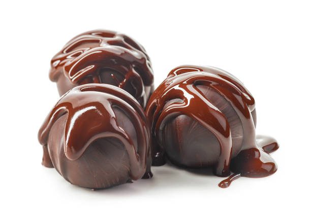 A group of chocolate covered balls on top of each other.