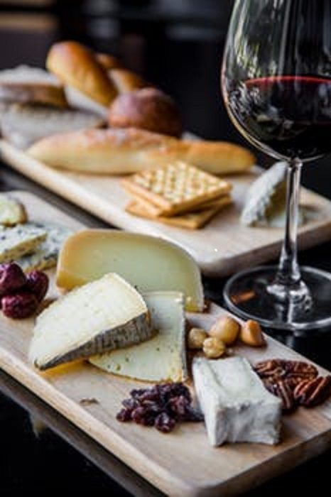 A wooden board with cheese and crackers on it