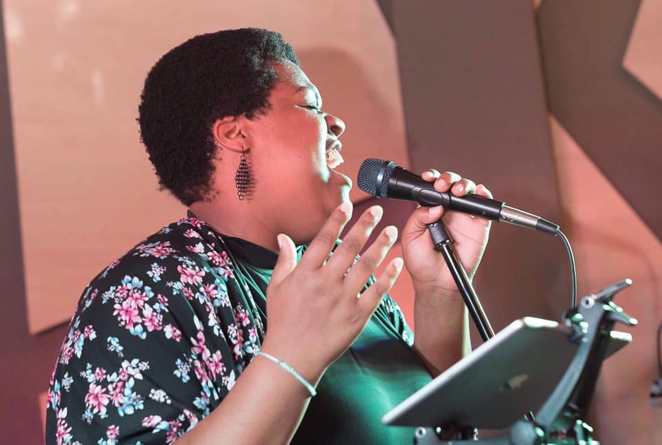 A person with a microphone and a microphone stand