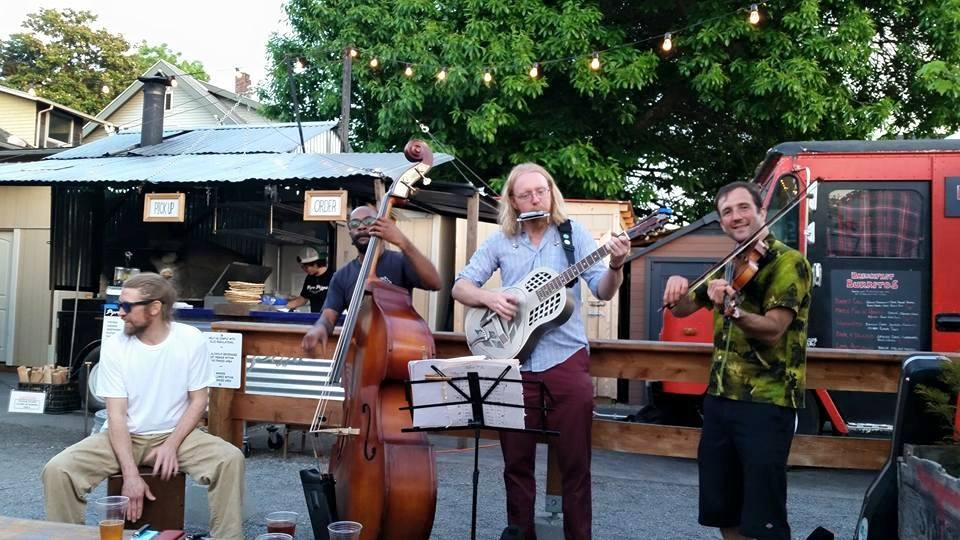 A group of people playing instruments on the street.
