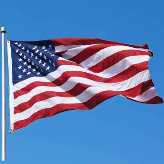A flag flying in the wind on a clear day.