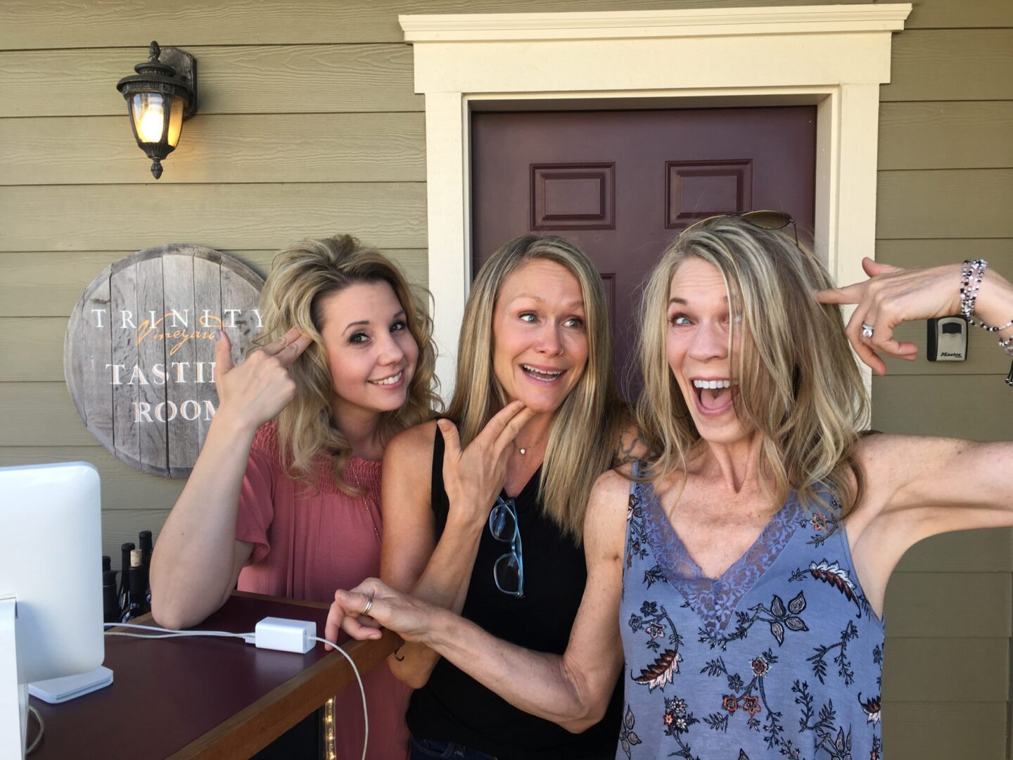 Three women posing for a picture in front of the door.