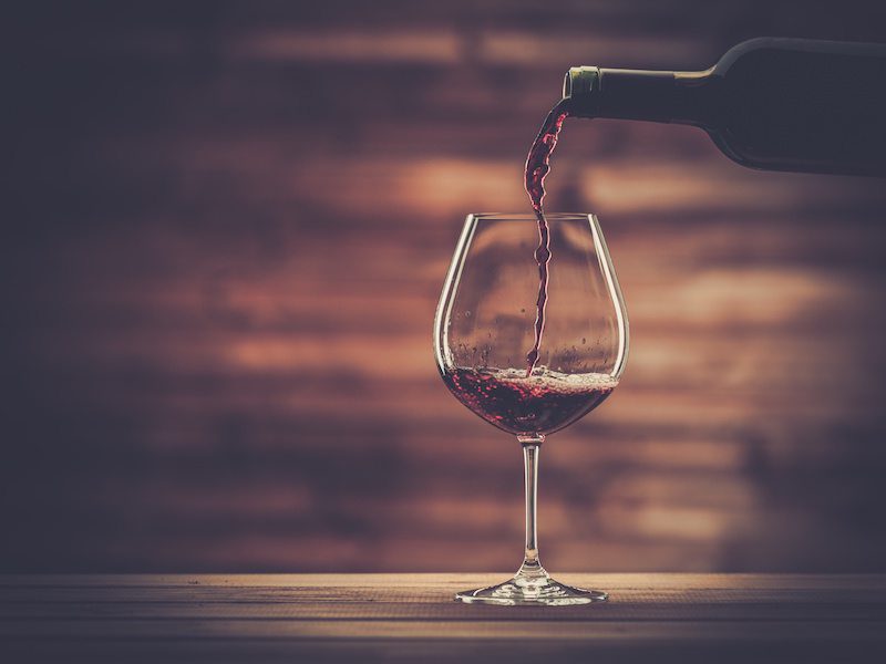 A glass of wine is being poured into it.