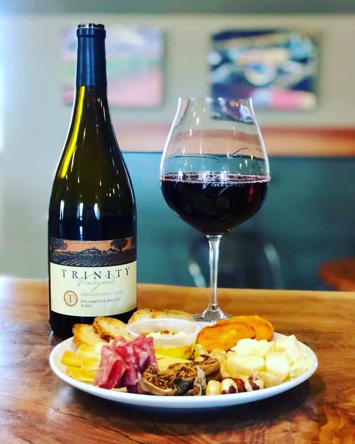 A plate of food and wine on the table.