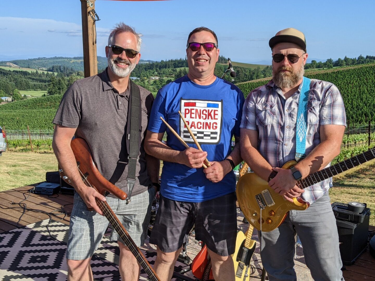 Three men standing next to each other holding guitars.